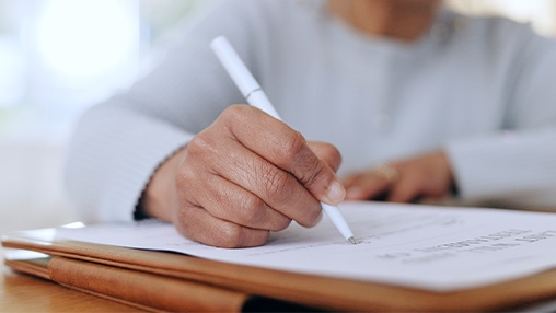 a person writing down on a paper